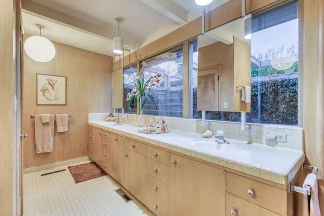 bathroom with wooden walls, tile patterned flooring, tasteful backsplash, and vanity