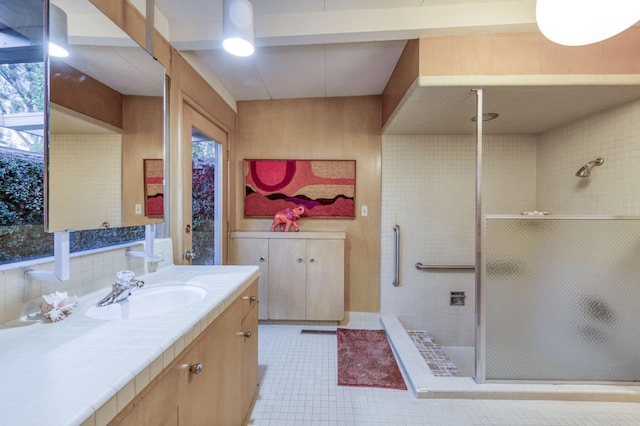 bathroom with a shower with shower door and vanity