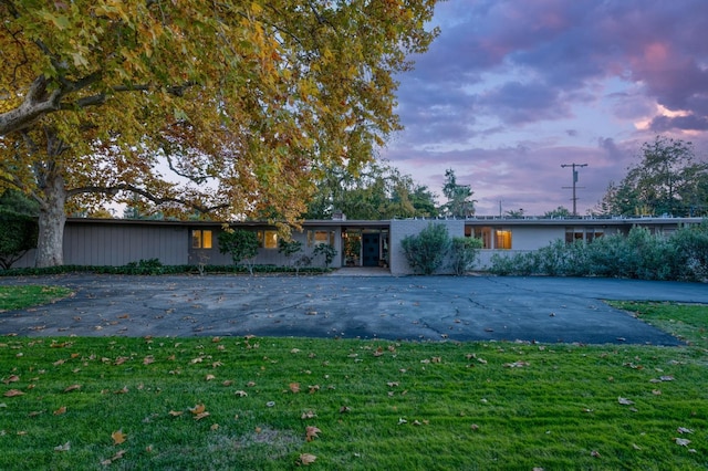 ranch-style home with a lawn