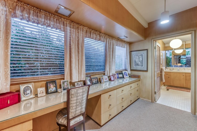 office area with built in desk and light colored carpet