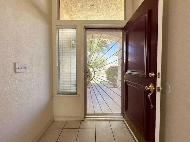 doorway to outside with light tile patterned floors