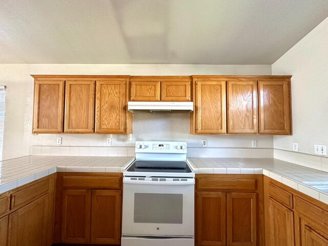 kitchen with tile countertops and white electric stove