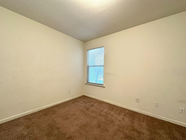 empty room featuring carpet floors and a textured ceiling