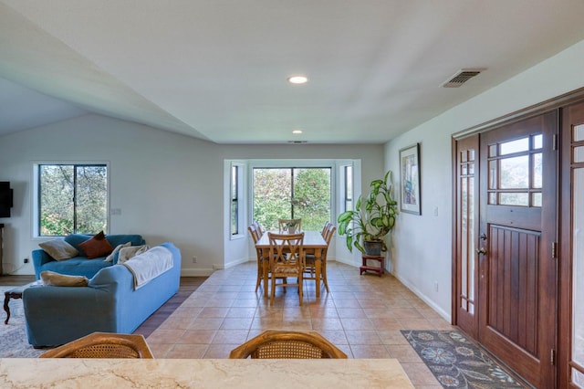 living room featuring light tile patterned flooring and vaulted ceiling