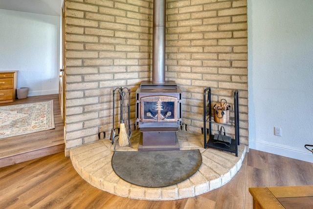 details featuring a wood stove and hardwood / wood-style floors