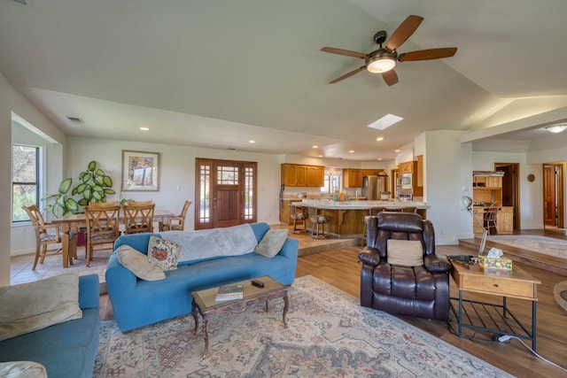 living room featuring a healthy amount of sunlight, light hardwood / wood-style floors, and ceiling fan