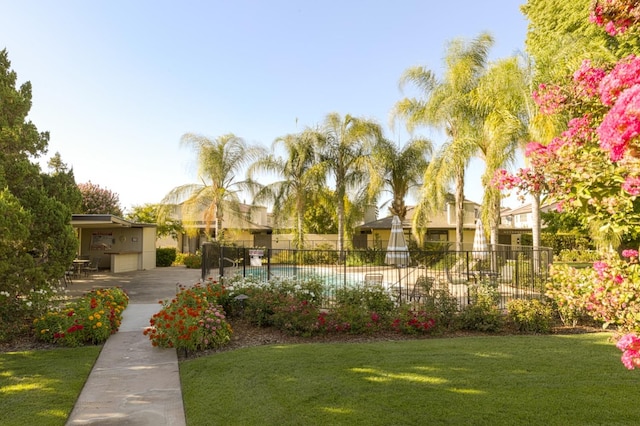 view of community featuring a pool, a lawn, and a patio