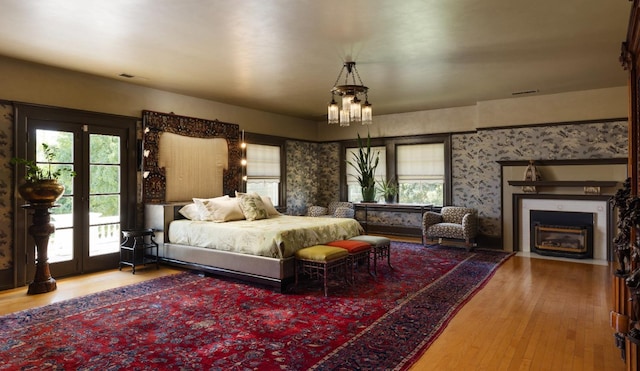 9486 E Lincoln Ave, Del Rey, CA 93616 - bedroom with a fireplace with flush hearth, an inviting chandelier, wood finished floors, access to exterior, and visible vents