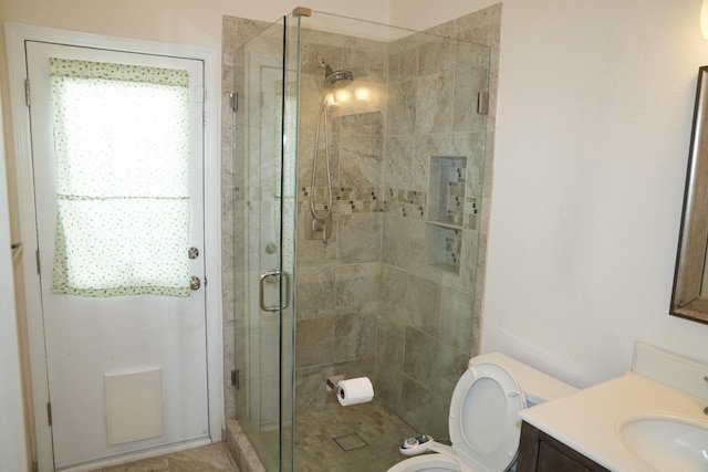 bathroom with walk in shower, vanity, and toilet