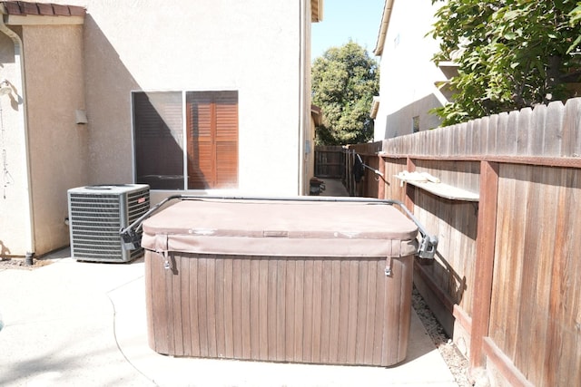 view of patio / terrace with a hot tub and central AC unit