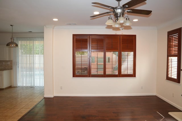 empty room featuring dark hardwood / wood-style flooring, ceiling fan, and crown molding