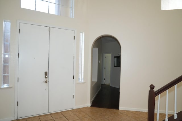 foyer entrance featuring light tile patterned floors and a healthy amount of sunlight