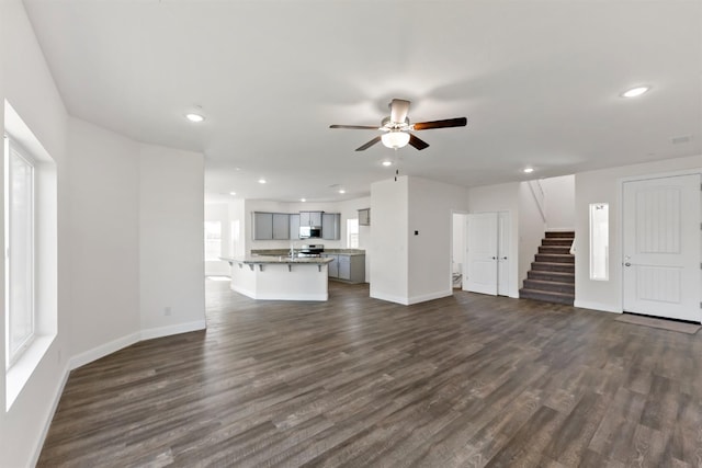 unfurnished living room with ceiling fan and dark hardwood / wood-style floors