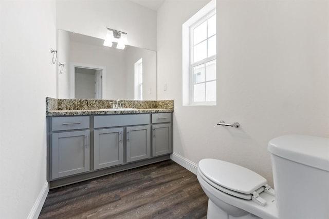 bathroom with hardwood / wood-style floors, vanity, and toilet