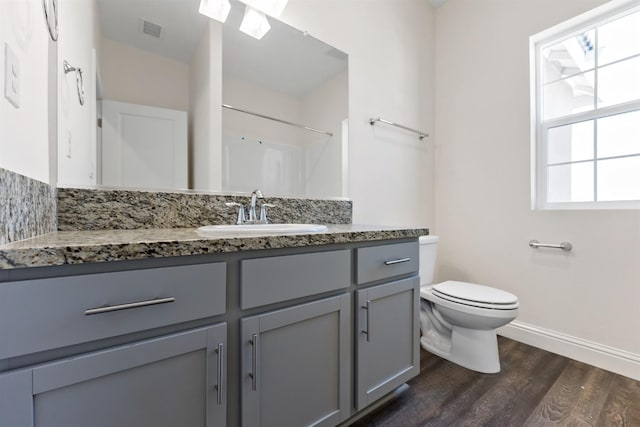 bathroom with wood-type flooring, a shower, vanity, and toilet