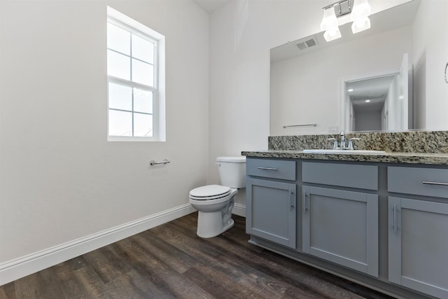 bathroom with vanity, toilet, and hardwood / wood-style flooring