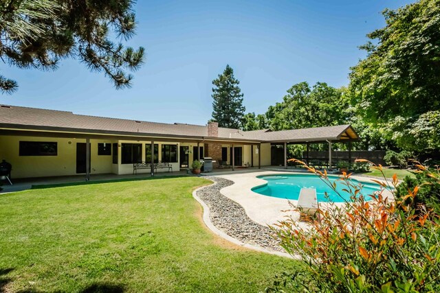 view of swimming pool featuring a patio and a lawn