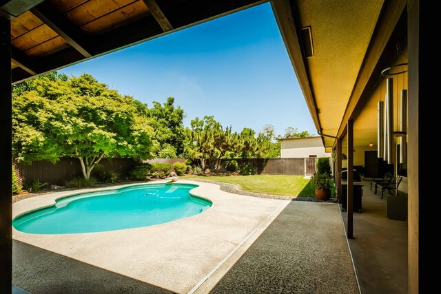 view of pool with a lawn and a patio