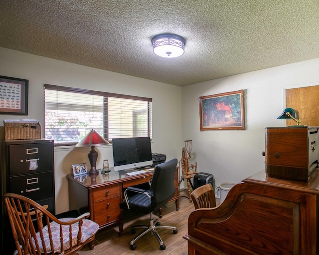 office with wood-type flooring and a textured ceiling