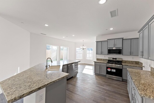 kitchen featuring a center island with sink, gray cabinets, sink, and stainless steel appliances