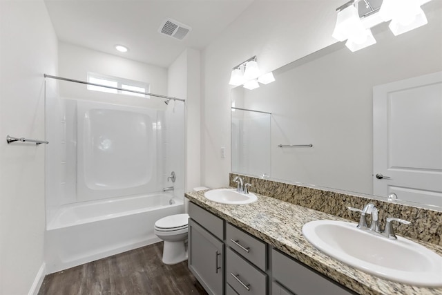 full bathroom with washtub / shower combination, hardwood / wood-style floors, vanity, and toilet