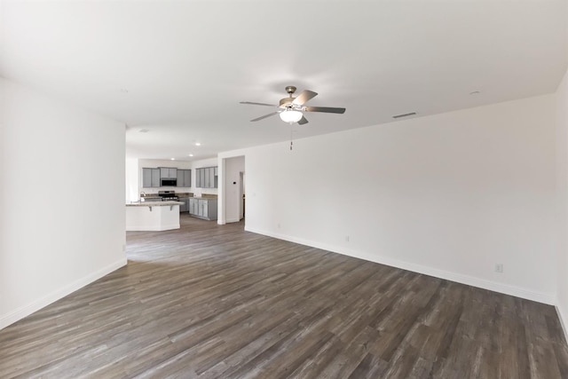 unfurnished living room featuring dark hardwood / wood-style flooring and ceiling fan