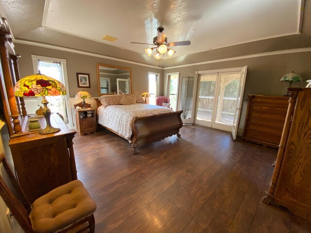 bedroom with a tray ceiling, visible vents, access to outside, crown molding, and wood-type flooring