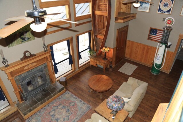 living area with wainscoting, wood walls, a ceiling fan, and wood finished floors