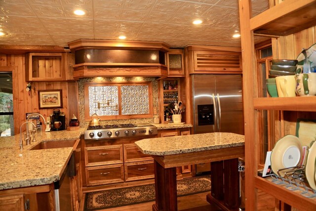 kitchen featuring stainless steel gas cooktop, a sink, brown cabinets, and an ornate ceiling