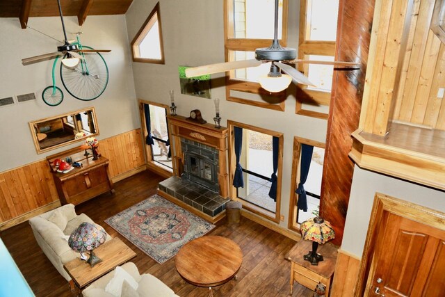 living area featuring a ceiling fan, wood walls, and hardwood / wood-style flooring