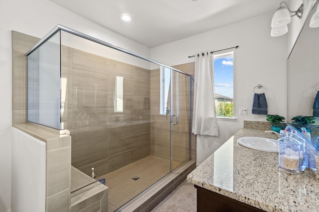 bathroom featuring walk in shower and vanity