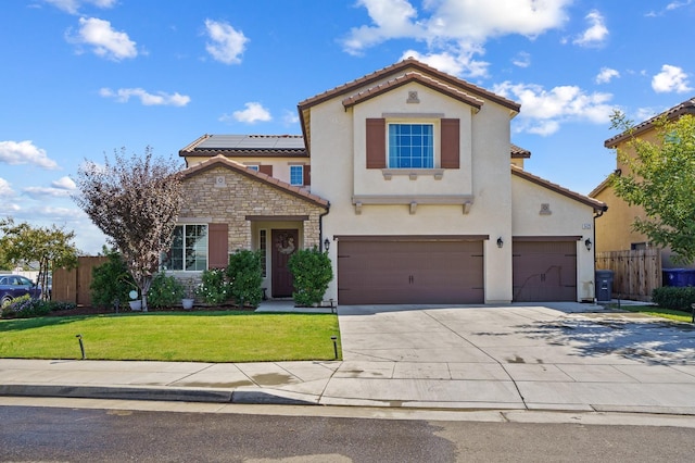 mediterranean / spanish home featuring a garage and a front lawn