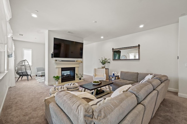 living room with a multi sided fireplace and carpet