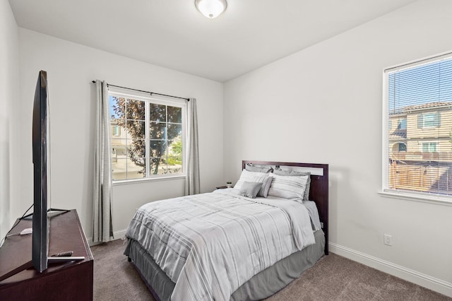 bedroom featuring multiple windows and dark carpet