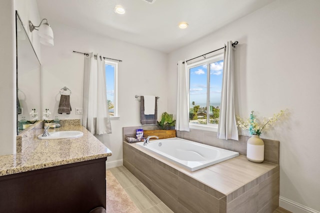 bathroom featuring tiled bath, vanity, and tile patterned floors