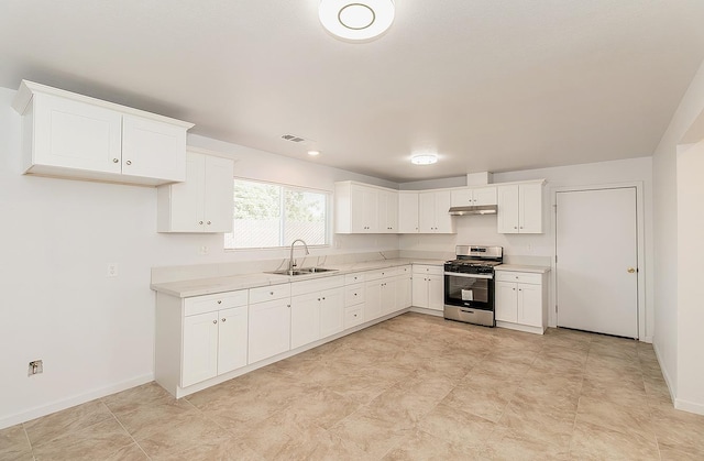 kitchen with gas stove, white cabinetry, and sink