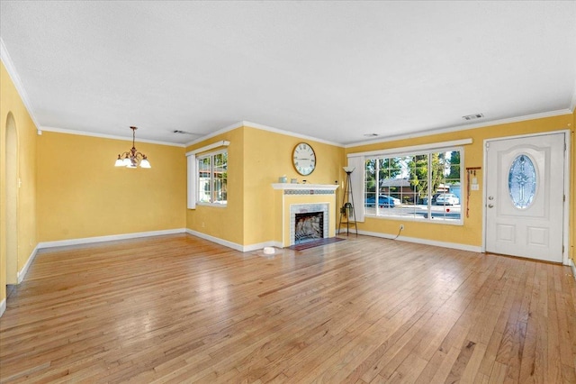 unfurnished living room with crown molding, a chandelier, and light wood-type flooring