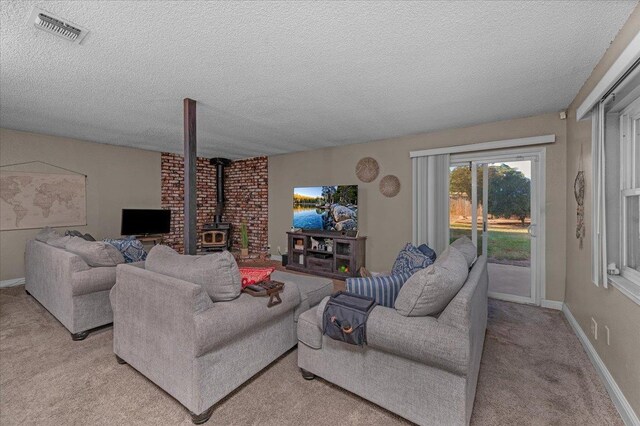 carpeted living room featuring a textured ceiling and a wood stove