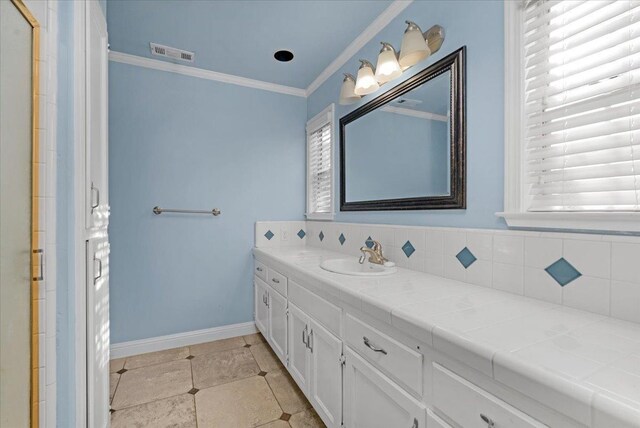 bathroom with tile patterned flooring, vanity, and ornamental molding