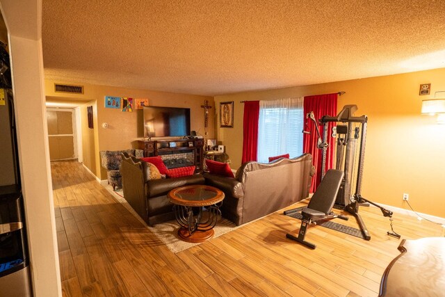 workout room with a textured ceiling and hardwood / wood-style flooring