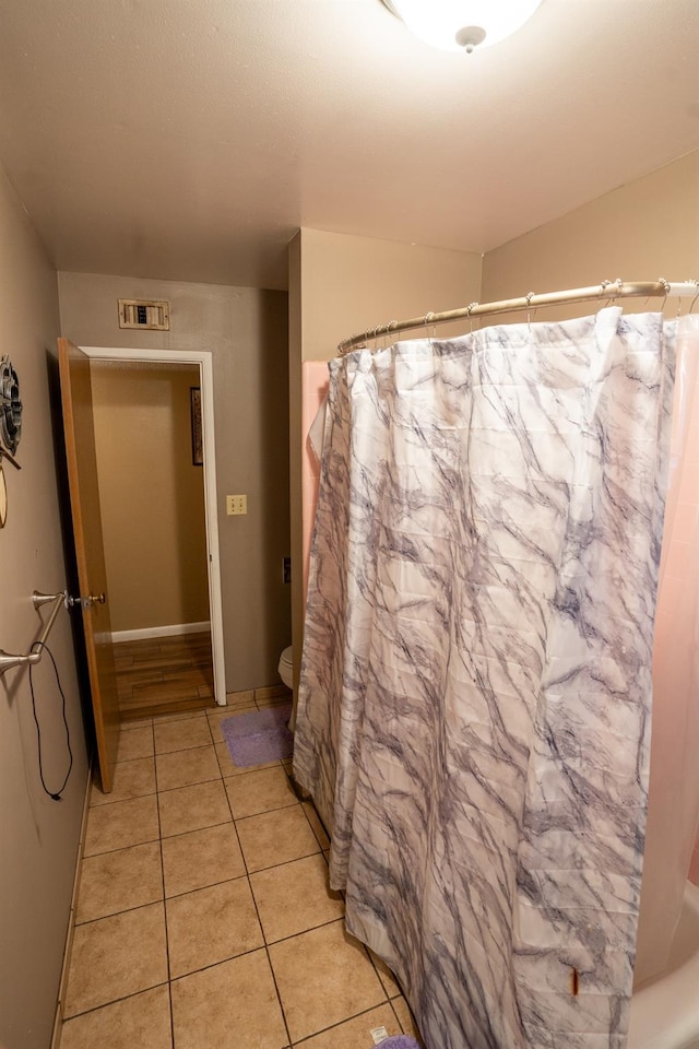 bathroom with toilet and tile patterned flooring