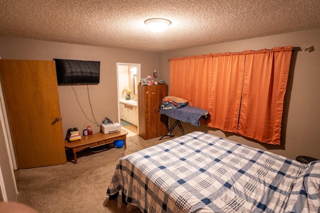 bedroom with a textured ceiling, carpet, and ensuite bath