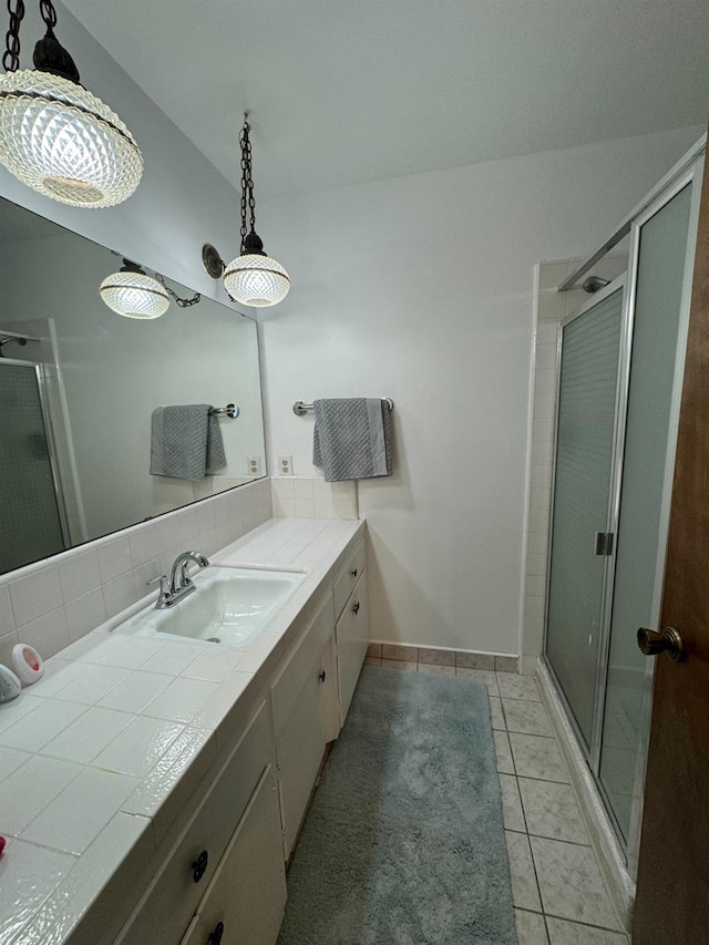 bathroom with tasteful backsplash, walk in shower, tile patterned floors, and vanity