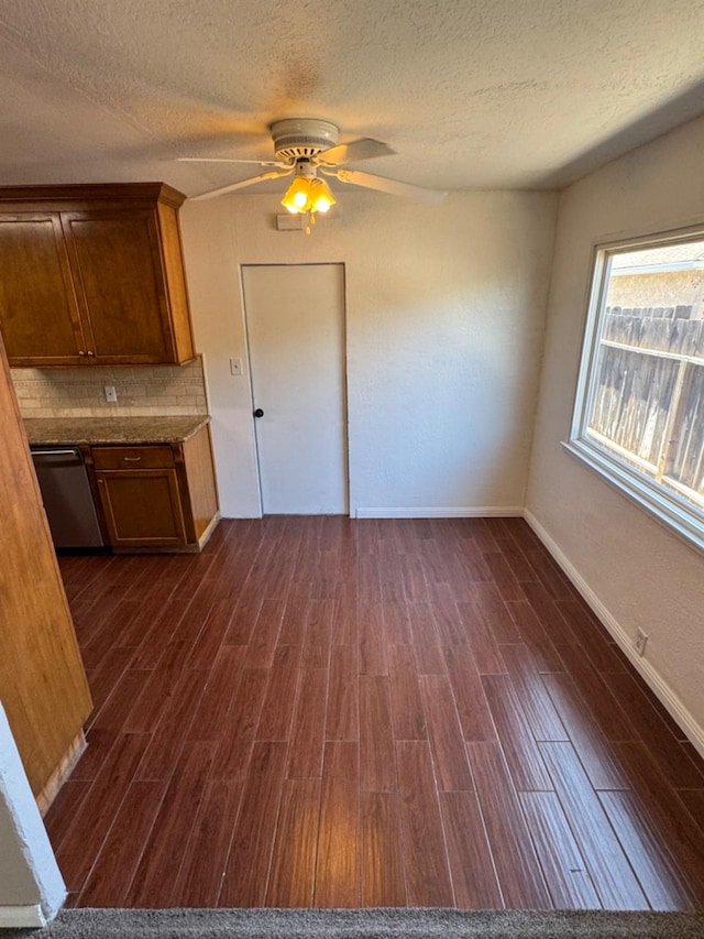 kitchen featuring ceiling fan, a textured ceiling, dishwasher, dark hardwood / wood-style floors, and decorative backsplash