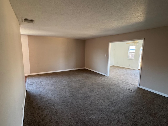 carpeted spare room featuring a textured ceiling and ceiling fan