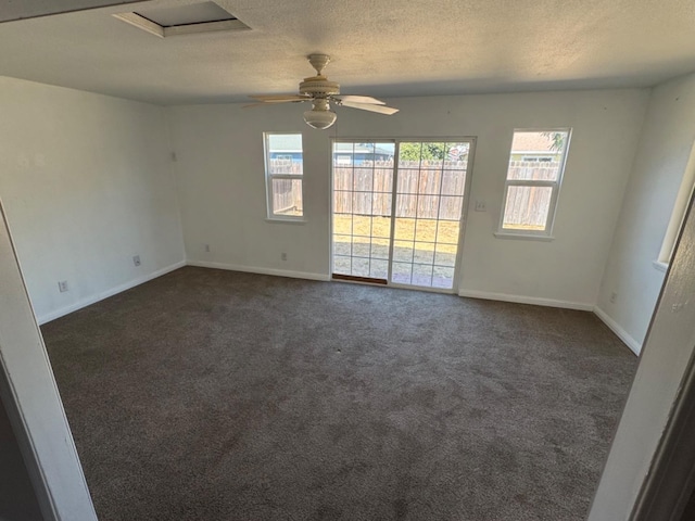 carpeted empty room with a textured ceiling, ceiling fan, and plenty of natural light