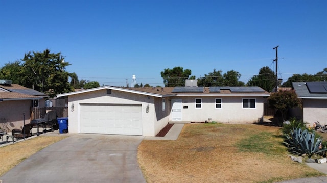 ranch-style house featuring a front yard, solar panels, and a garage