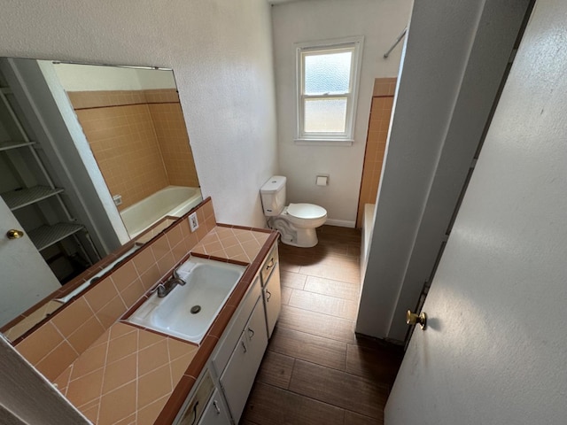 full bathroom featuring backsplash, vanity, toilet, and tiled shower / bath