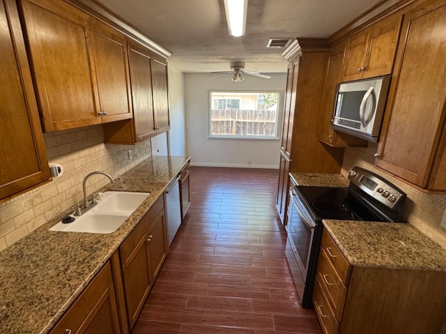 kitchen featuring appliances with stainless steel finishes, backsplash, ceiling fan, dark hardwood / wood-style floors, and sink