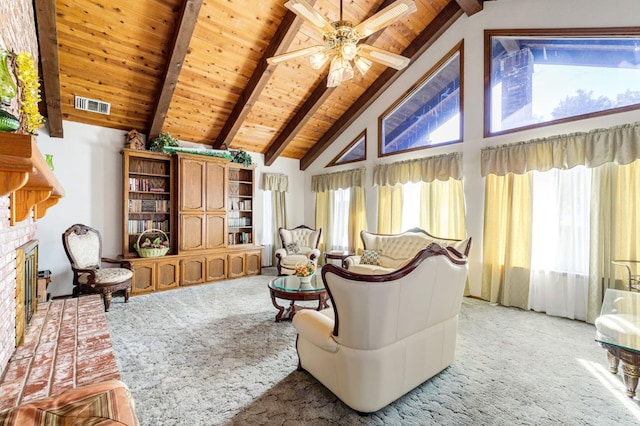 living area with carpet floors, ceiling fan, beamed ceiling, and a wealth of natural light